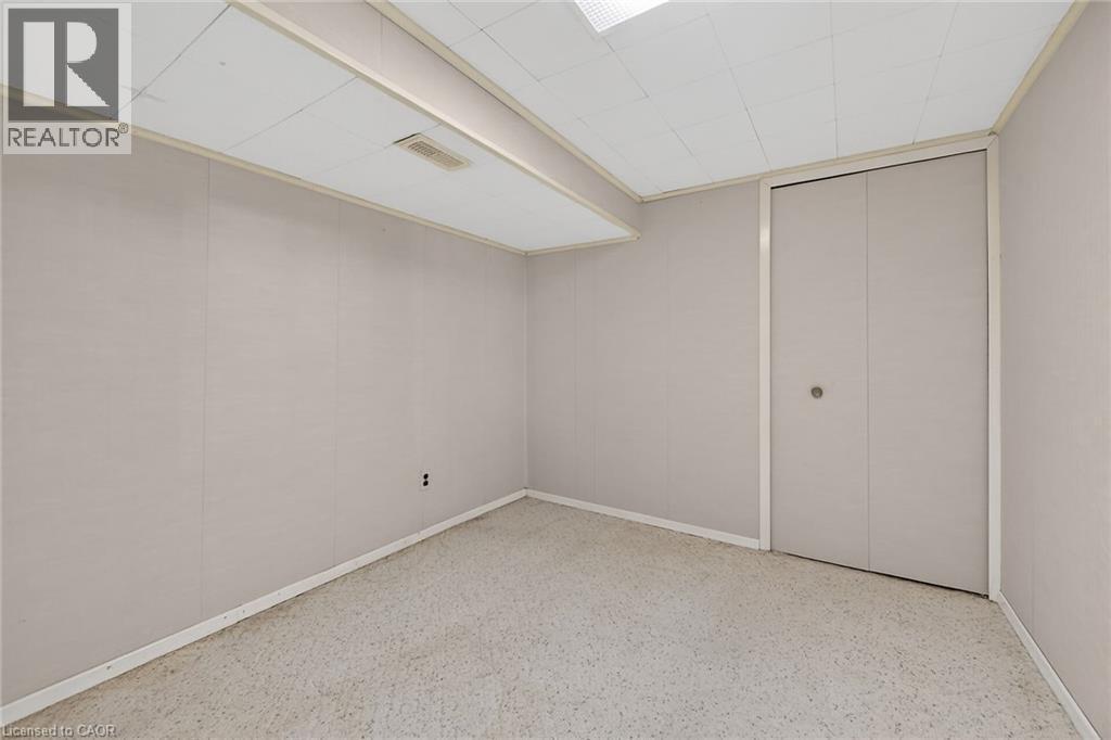 Unfurnished bedroom featuring dark speckled floor and a closet - 21 Bluebird Avenue, Hamilton, ON - Indoor Photo Showing Other Room