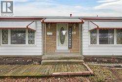 Entrance to property with stone siding and a porch -