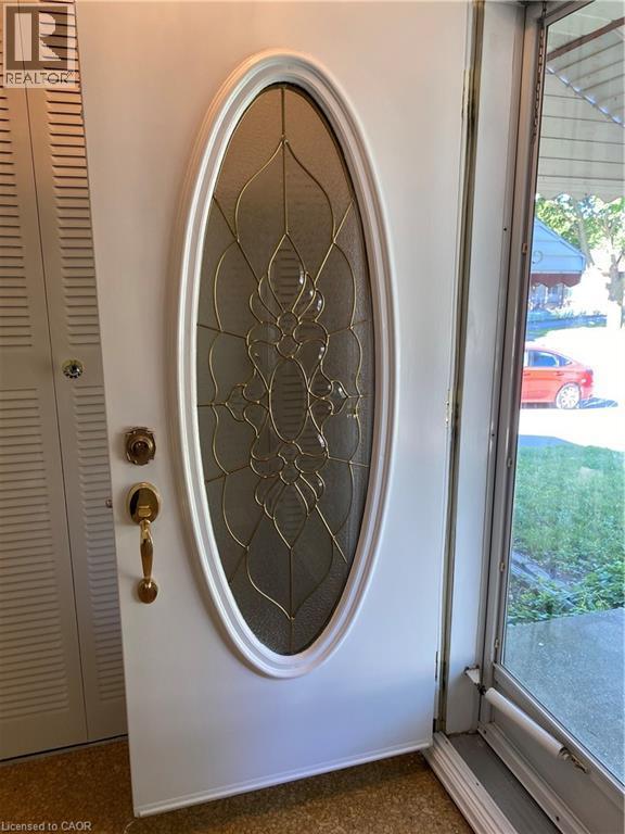 White entry door featuring an oval leaded glass insert - 21 Bluebird Avenue, Hamilton, ON