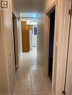 Hallway with light-colored square floor tiles and neutral wall tones -