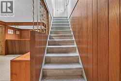 Stairs featuring wood walls -