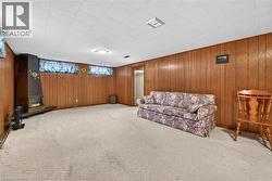 Living area with carpet flooring and wooden walls -