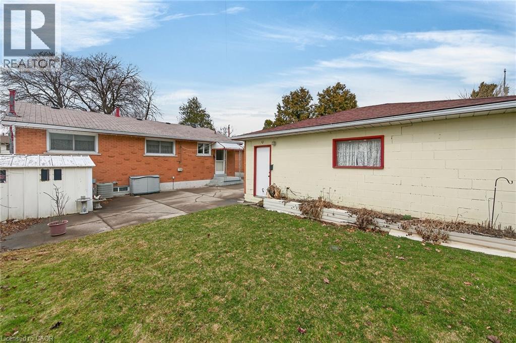 Back of property with a lawn and a patio - 21 Bluebird Avenue, Hamilton, ON