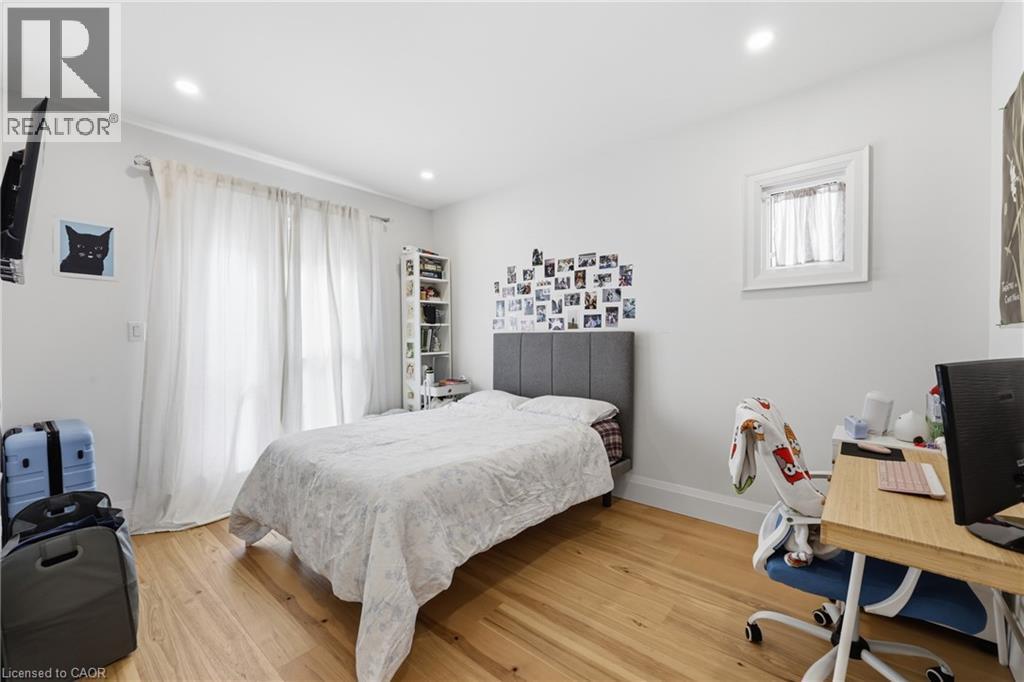 Bedroom with an office area, light wood finished floors, and recessed lighting - 129 Jackson Street W, Hamilton, ON - Indoor Photo Showing Bedroom