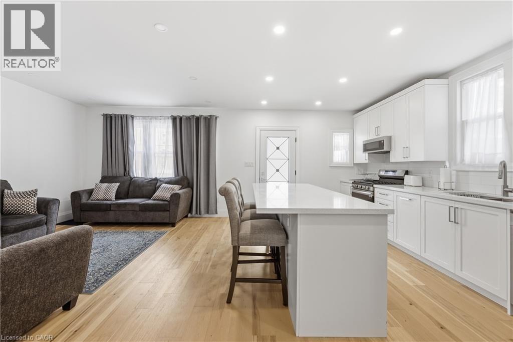 Kitchen featuring a kitchen bar, recessed lighting, stainless steel appliances, a center island, and open floor plan - 129 Jackson Street W, Hamilton, ON - Indoor
