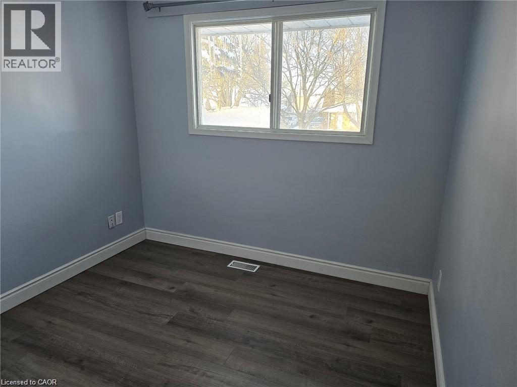 Unfurnished room with dark wood-type flooring and baseboards - 593 Mount Anne Drive, Waterloo, ON - Indoor Photo Showing Other Room