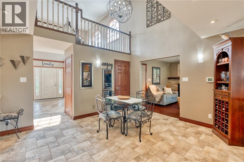 Dining area featuring stone finish floors, suspended lighting, a high ceiling, and a fireplace - 15 Marquette Drive, Kitchener, ON - Indoor