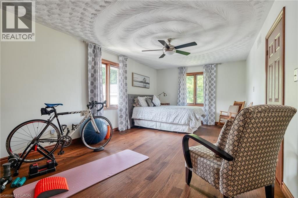 Bedroom featuring multiple windows, hardwood / wood-style floors, and a ceiling fan - 15 Marquette Drive, Kitchener, ON - Indoor Photo Showing Bedroom
