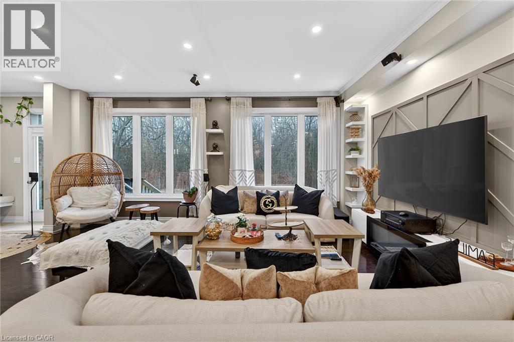 Living area with wood finished floors, crown molding, plenty of natural light, recessed lighting, and built in features - 7809 Hackberry Trail E, Niagara Falls, ON - Indoor Photo Showing Living Room