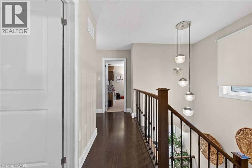 Corridor featuring dark wood-style flooring and an upstairs landing - 7809 Hackberry Trail E, Niagara Falls, ON - Indoor Photo Showing Other Room