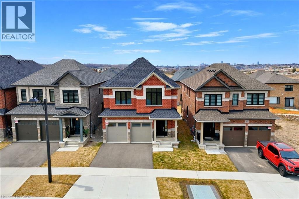 View of front facade with a residential view, driveway, an attached garage, and brick siding - 39 Guernsey Drive, Kitchener, ON - Outdoor With Facade
