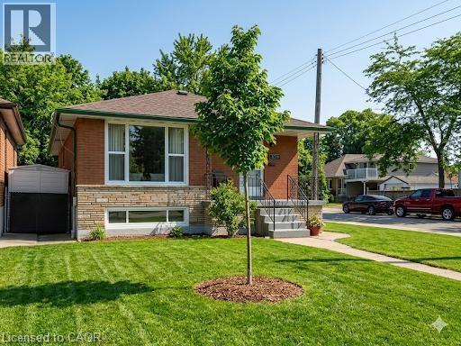 View of front of home featuring a front lawn, stone siding, and brick siding - 1224 Dunsmure Road, Hamilton, ON - Outdoor