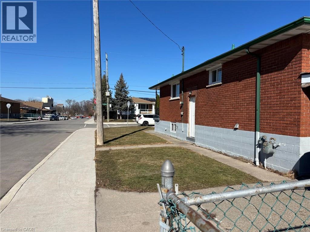 View of side of property with a yard and brick siding - 1224 Dunsmure Road, Hamilton, ON - Outdoor With Exterior