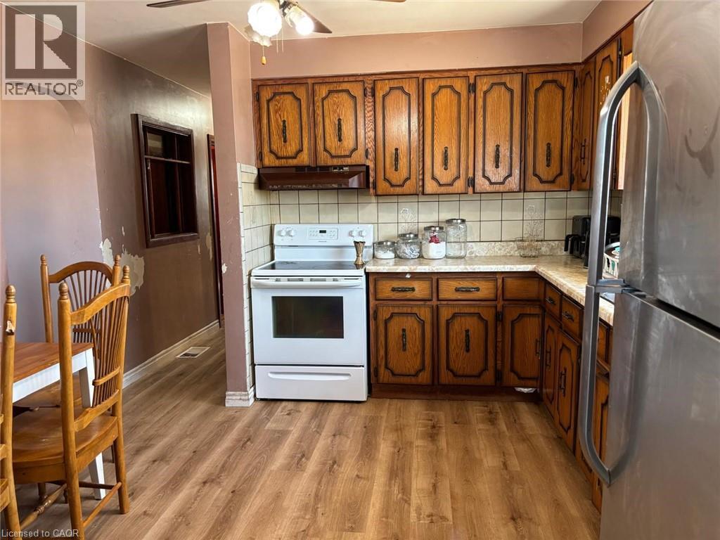 Kitchen with light countertops, arched walkways, freestanding refrigerator, electric range, and tasteful backsplash - 1224 Dunsmure Road, Hamilton, ON - Indoor Photo Showing Kitchen