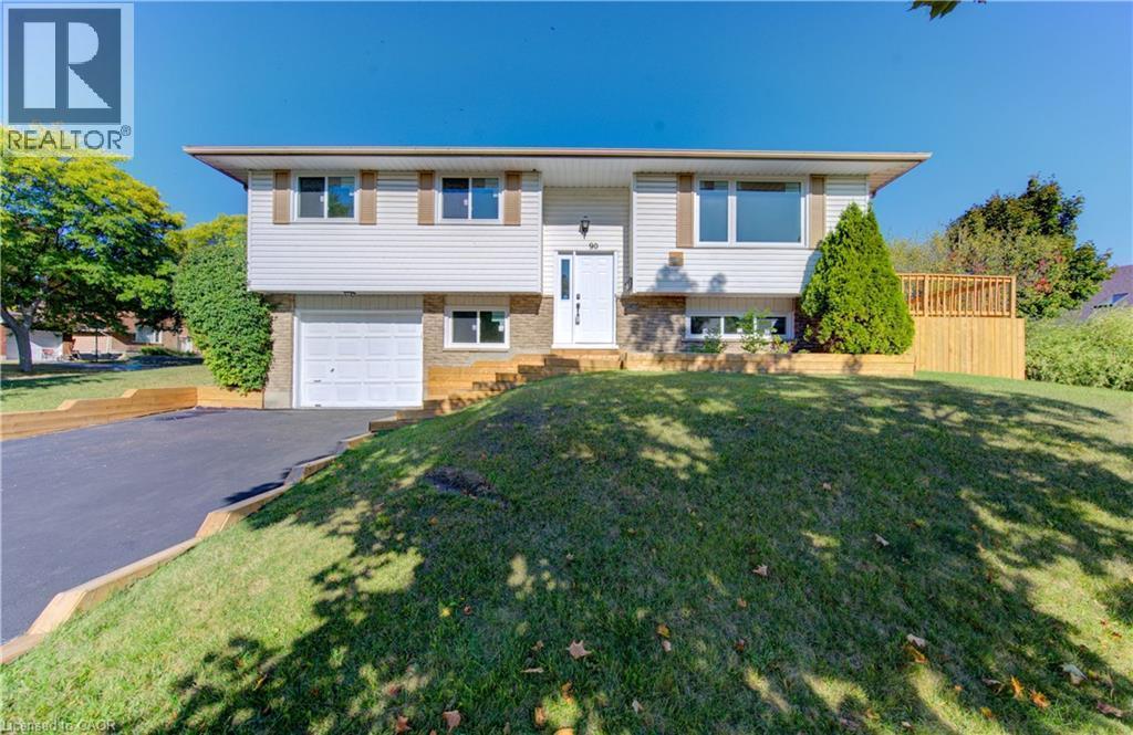 Bi-level home with brick siding, asphalt driveway, a front yard, and a garage - 90 Culpepper Drive, Waterloo, ON - Outdoor