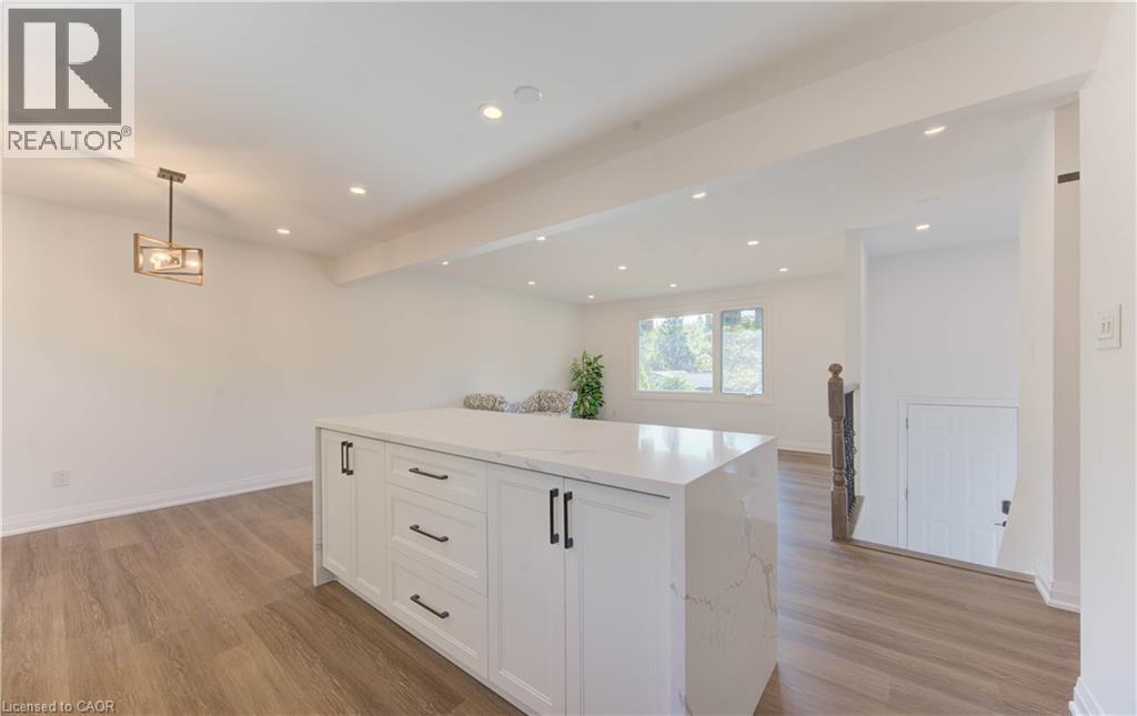 Kitchen featuring white cabinetry, hanging light fixtures, recessed lighting, light stone counters, and light wood-style floors - 90 Culpepper Drive, Waterloo, ON - Indoor