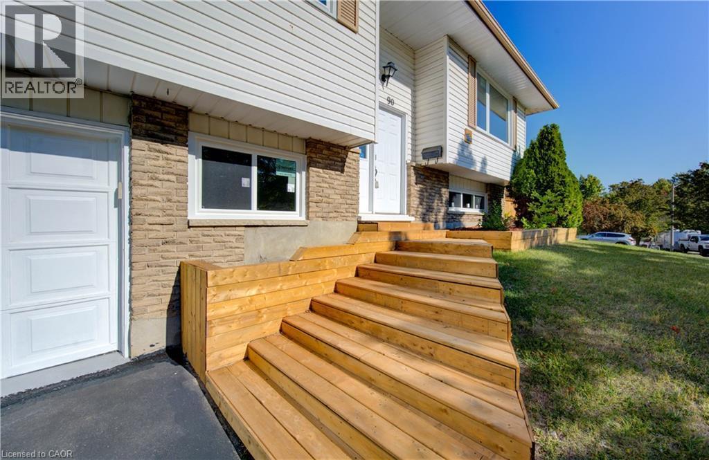 Doorway to property featuring brick siding, a garage, and a lawn - 90 Culpepper Drive, Waterloo, ON - Outdoor