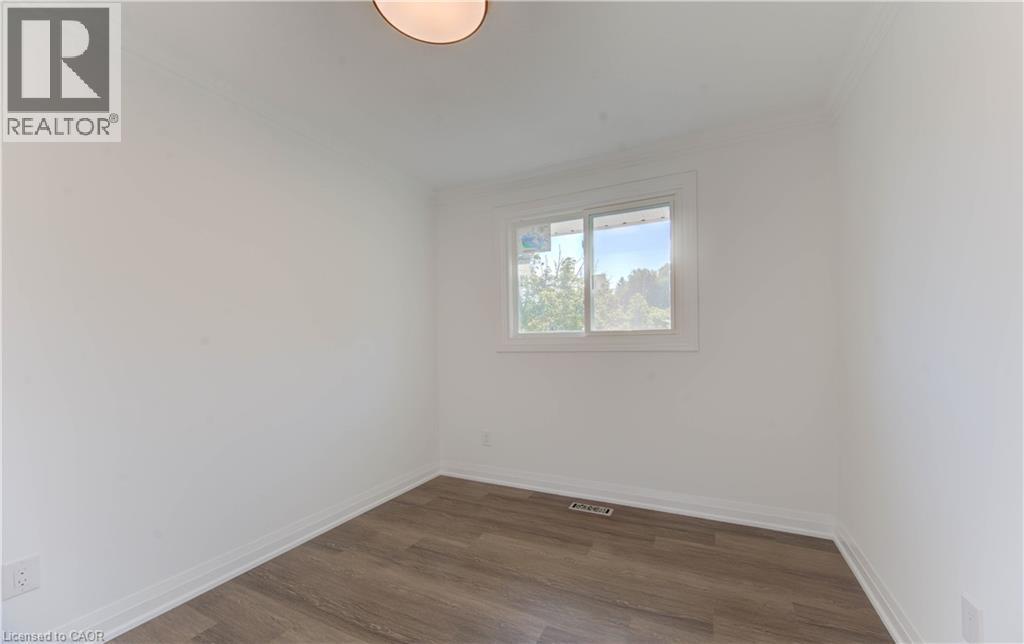 Unfurnished room featuring wood finished floors and ornamental molding - 90 Culpepper Drive, Waterloo, ON - Indoor Photo Showing Other Room