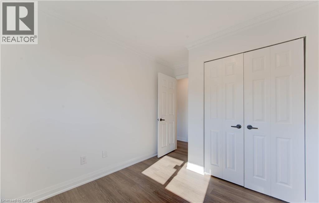 Unfurnished bedroom featuring wood finished floors, crown molding, and a closet - 90 Culpepper Drive, Waterloo, ON - Indoor Photo Showing Other Room