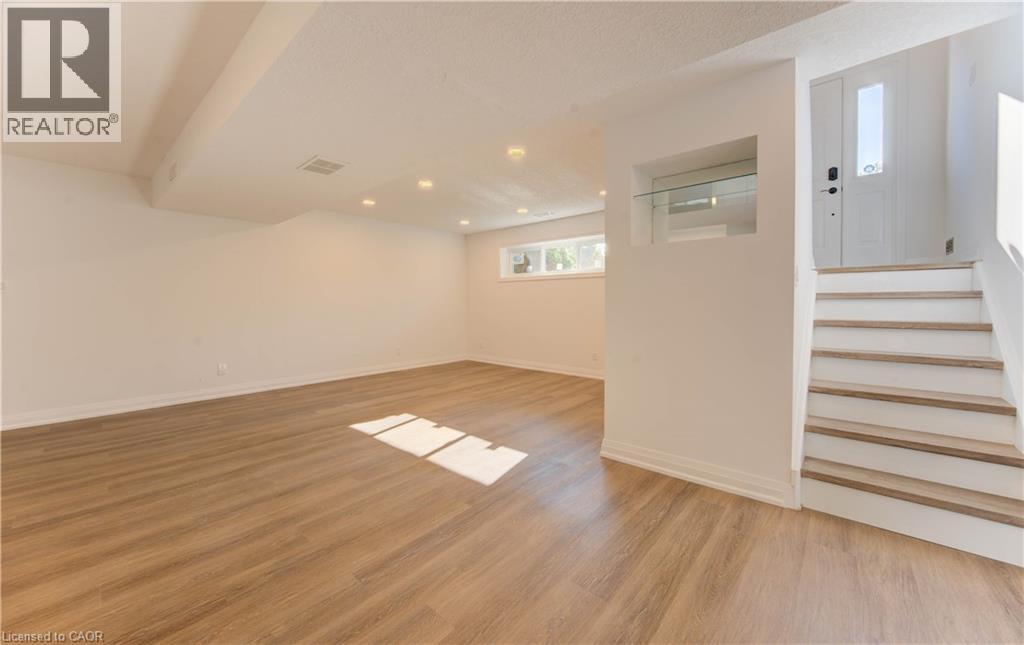 Basement with light wood finished floors, stairs, and recessed lighting - 90 Culpepper Drive, Waterloo, ON - Indoor Photo Showing Other Room