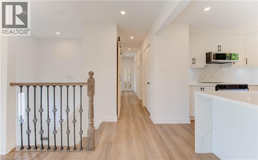 Hall featuring a barn door, recessed lighting, and light wood-style floors - 90 Culpepper Drive, Waterloo, ON - Indoor