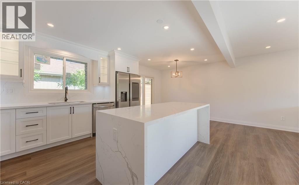 Kitchen featuring white cabinets, recessed lighting, appliances with stainless steel finishes, beamed ceiling, and decorative light fixtures - 90 Culpepper Drive, Waterloo, ON - Indoor Photo Showing Kitchen With Upgraded Kitchen