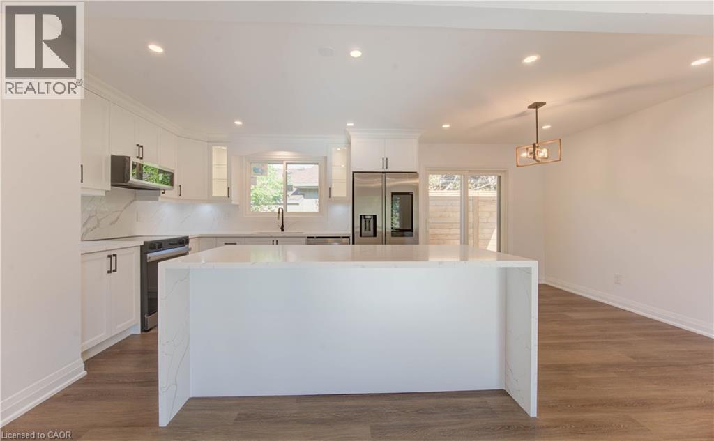 Kitchen featuring recessed lighting, white cabinetry, hanging light fixtures, appliances with stainless steel finishes, and a center island - 90 Culpepper Drive, Waterloo, ON - Indoor Photo Showing Kitchen With Upgraded Kitchen