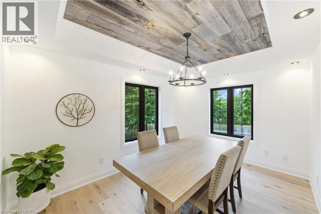 Dining space featuring large windows, tray ceiling with barn board finish, additional recessed lighting, chandelier - 515 Hamilton Drive, Ancaster, ON - Indoor Photo Showing Dining Room