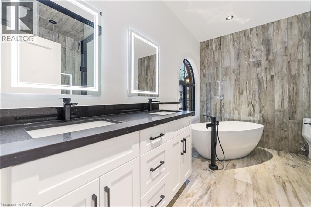 Heated flooring, touch LED vanity mirrors with dual light control, free standing tub, matching tile wall, dual vanity - 515 Hamilton Drive, Ancaster, ON - Indoor Photo Showing Bathroom