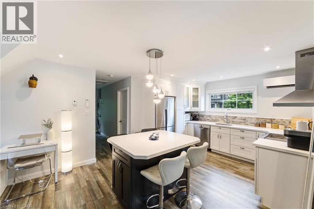 Guest house kitchen with white cabinetry, stainless steel appliances including fridge, stove, dishwasher and hood, island seating for 4 - 515 Hamilton Drive, Ancaster, ON - Indoor