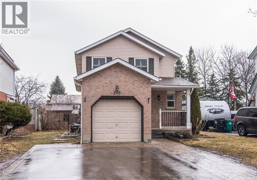 Traditional-style home with a porch, asphalt driveway, a gate, a garage, and brick siding - 236 Dartmoor Crescent, Waterloo, ON - Outdoor