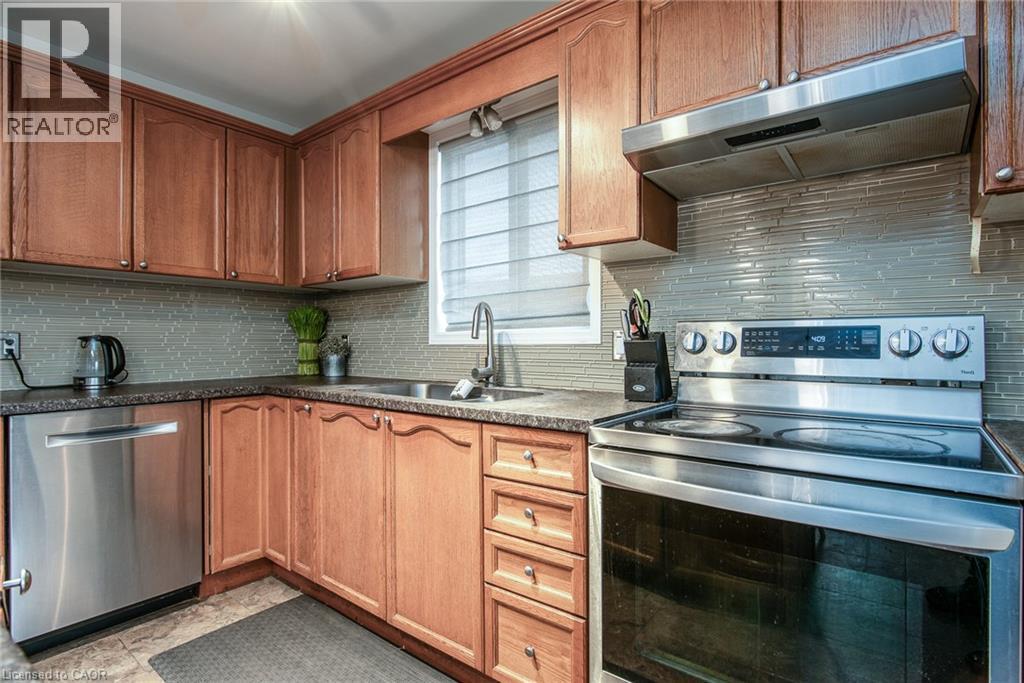 Kitchen featuring stainless steel appliances, tasteful backsplash, and wood finish cabinetry - 236 Dartmoor Crescent, Waterloo, ON - Indoor Photo Showing Kitchen