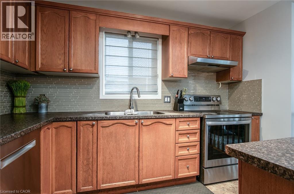 Kitchen featuring dark countertops, electric stove, wood finish cabinets, and decorative backsplash - 236 Dartmoor Crescent, Waterloo, ON - Indoor Photo Showing Kitchen