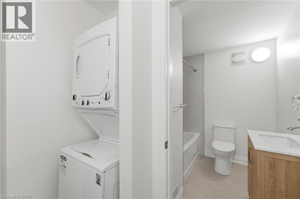 Bathroom with vanity, stacked washer / drying machine, and tub / shower combination - 187 Oak Avenue Unit# Lower, Hamilton, ON - Indoor