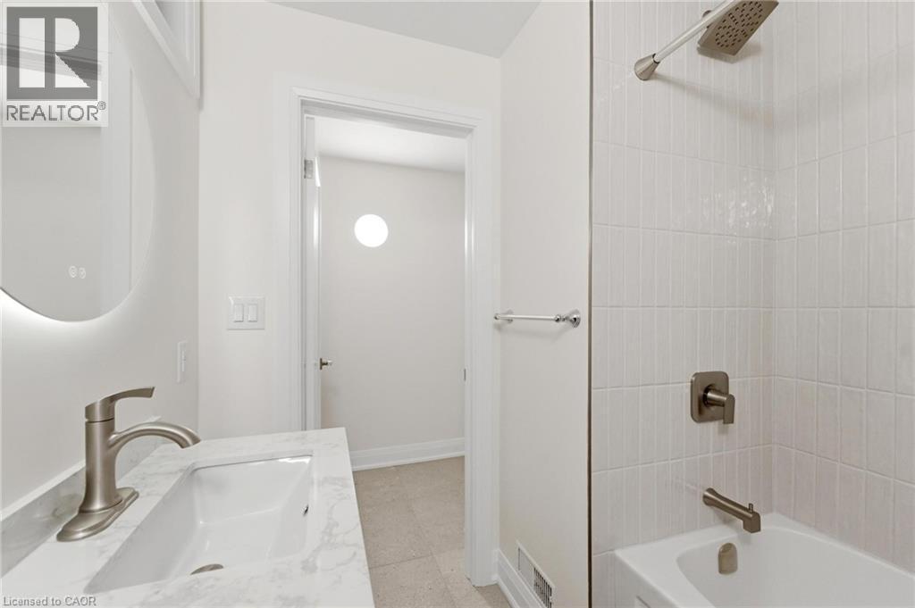 Full bath with vanity, bathing tub / shower combination, and light tile patterned flooring - 187 Oak Avenue Unit# Lower, Hamilton, ON - Indoor Photo Showing Bathroom