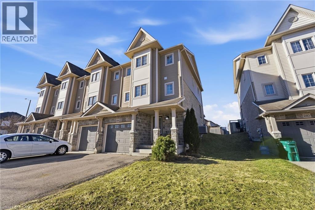 View of front facade with driveway, a front lawn, an attached garage, and stone siding - 208 Templewood Drive, Kitchener, ON - Outdoor With Facade