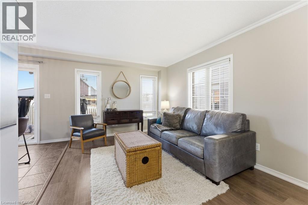 Living room featuring wood finished floors, ornamental molding, and plenty of natural light - 208 Templewood Drive, Kitchener, ON - Indoor Photo Showing Living Room