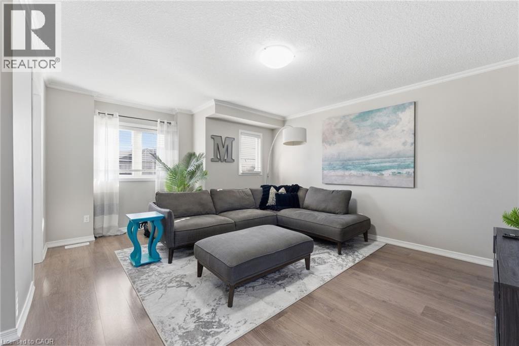 Living area with light wood-type flooring, crown molding, and a textured ceiling - 208 Templewood Drive, Kitchener, ON - Indoor Photo Showing Living Room