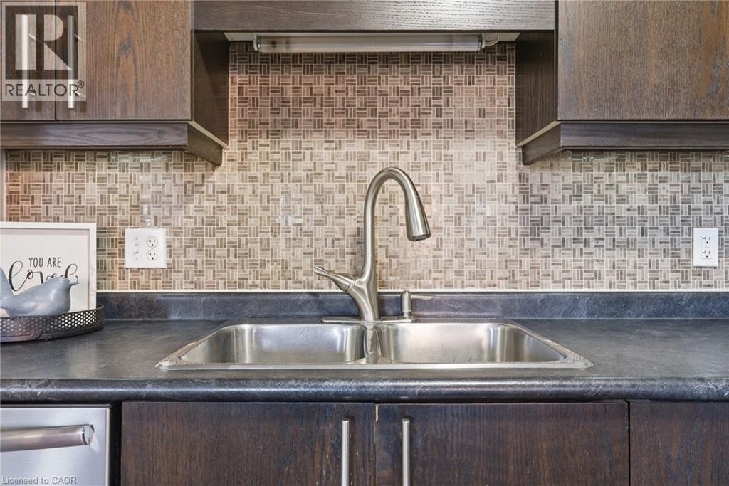 Kitchen with dark wood finish cabinets, dark countertops, backsplash, and stainless steel dishwasher - 208 Templewood Drive, Kitchener, ON - Indoor Photo Showing Kitchen With Double Sink