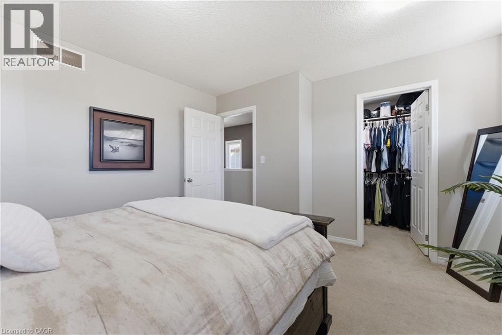 Bedroom with light colored carpet, a walk in closet, and a textured ceiling - 208 Templewood Drive, Kitchener, ON - Indoor Photo Showing Bedroom
