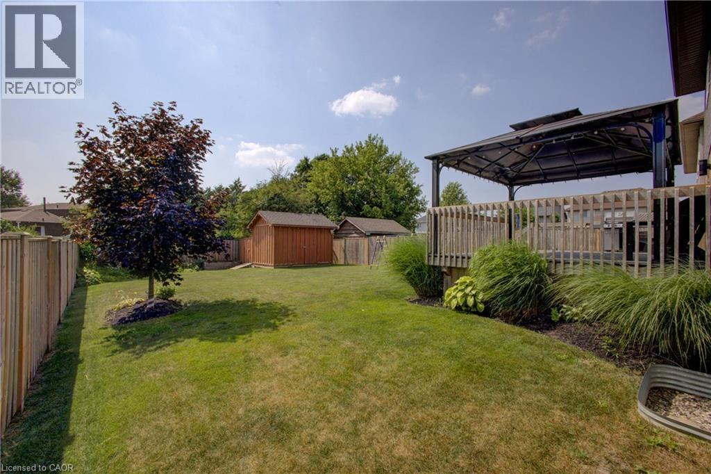 Fenced backyard with a shed and a trampoline - 128 Schmidt Drive, Arthur, ON - Outdoor