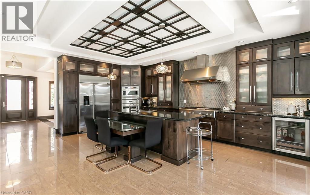 Kitchen with a kitchen breakfast bar, stainless steel appliances, beverage cooler, dark wood finish cabinetry, and a raised ceiling - 24 Jacob Gingrich Drive, Kitchener, ON - Indoor Photo Showing Kitchen With Upgraded Kitchen