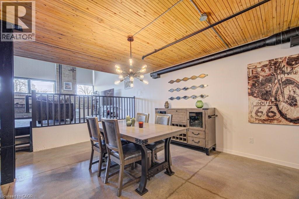 Dining space featuring finished concrete floors, wooden ceiling, and hanging lights - 85 Spruce Street Unit# 103, Cambridge, ON - Indoor Photo Showing Dining Room