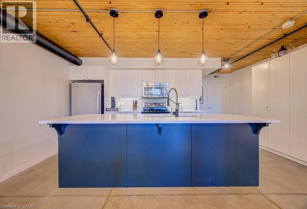 Kitchen featuring hanging light fixtures, stainless steel appliances, a kitchen breakfast bar, and white cabinets - 85 Spruce Street Unit# 103, Cambridge, ON - Indoor Photo Showing Kitchen With Upgraded Kitchen