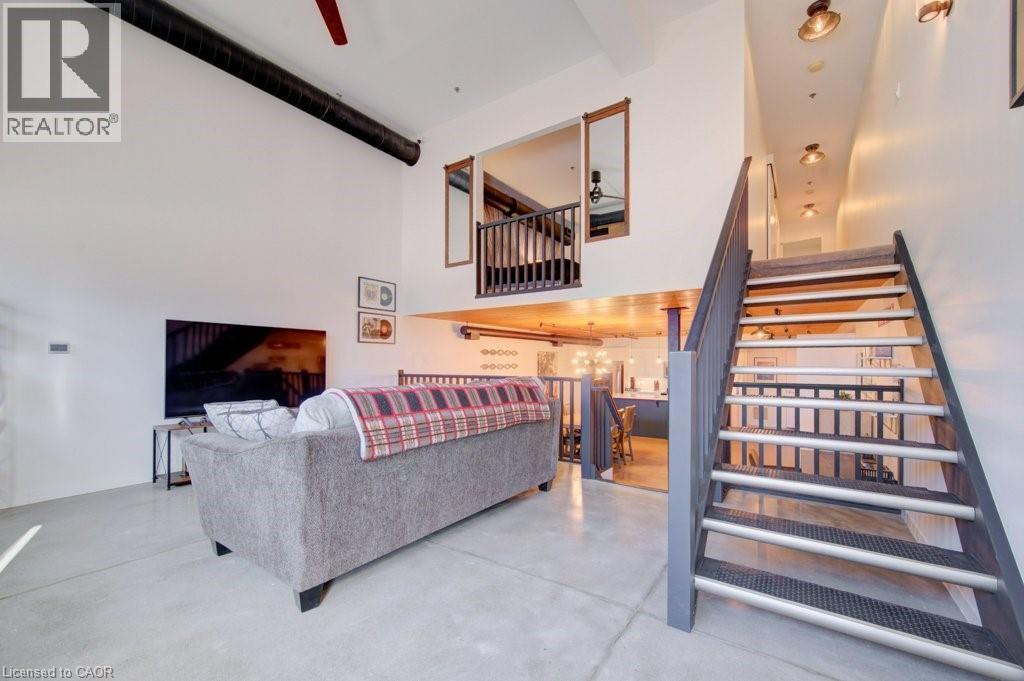 Living area featuring finished concrete floors, a high ceiling, and ceiling fan - 85 Spruce Street Unit# 103, Cambridge, ON - Indoor Photo Showing Other Room