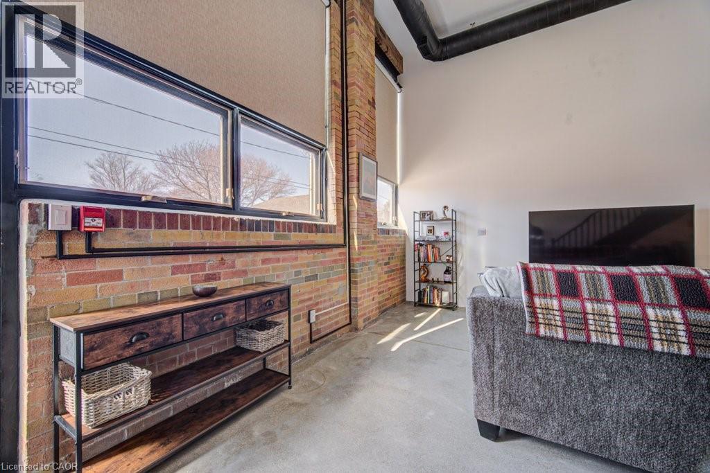 Bedroom with concrete flooring and brick wall - 85 Spruce Street Unit# 103, Cambridge, ON - Indoor