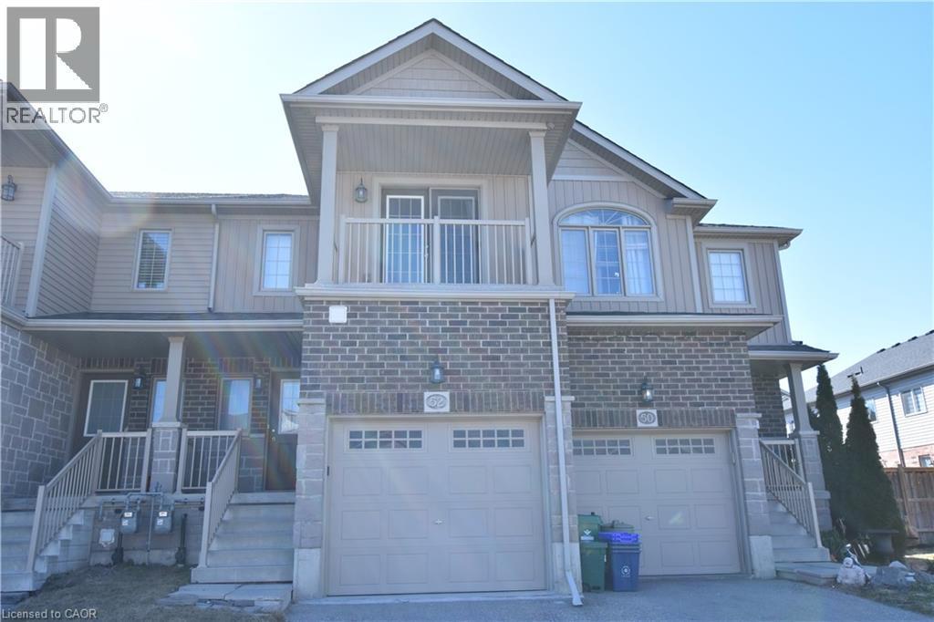 View of front of property featuring a porch, a garage, driveway, and brick siding - 52 Meadowridge Street, Kitchener, ON - Outdoor With Facade