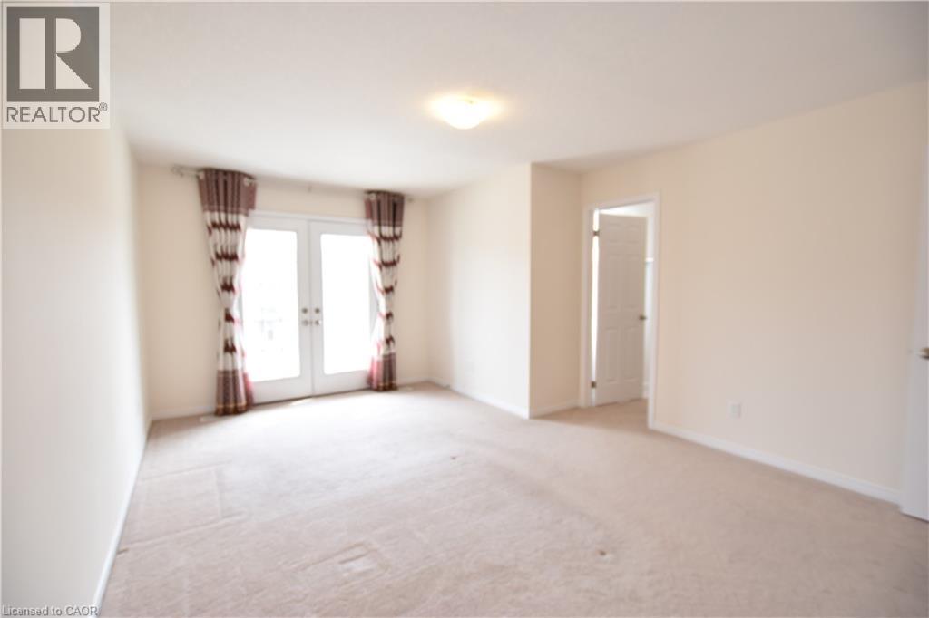 Spare room with french doors and light carpet - 52 Meadowridge Street, Kitchener, ON - Indoor Photo Showing Other Room