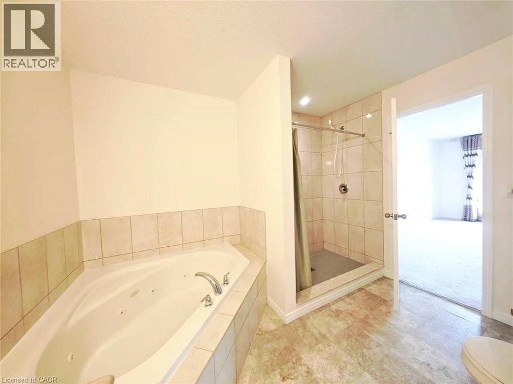 Bathroom featuring a shower stall and a tub with jets - 52 Meadowridge Street, Kitchener, ON - Indoor Photo Showing Bathroom