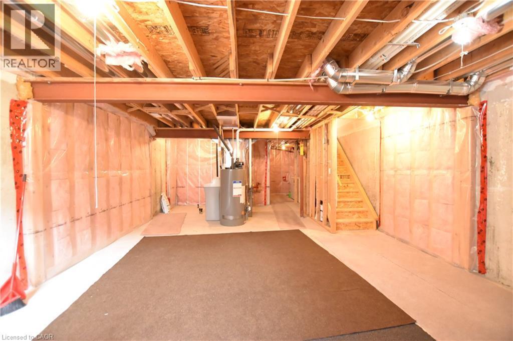 Unfinished basement featuring a water softener system and water heater - 52 Meadowridge Street, Kitchener, ON - Indoor Photo Showing Basement